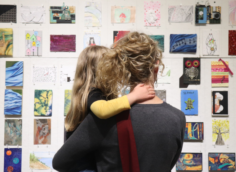 Mother and daughter looking at art on display