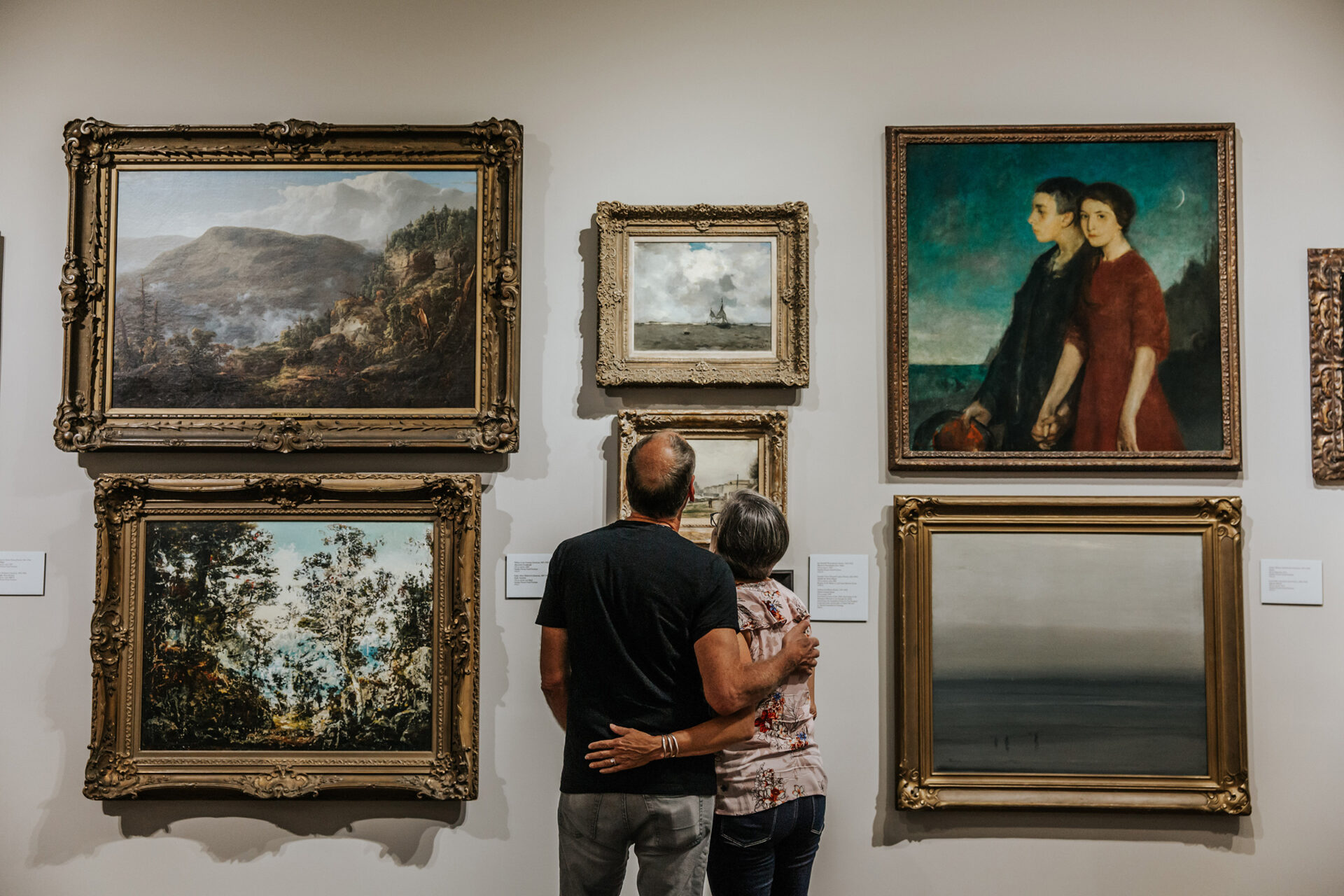 Couple looking at framed artwork on display